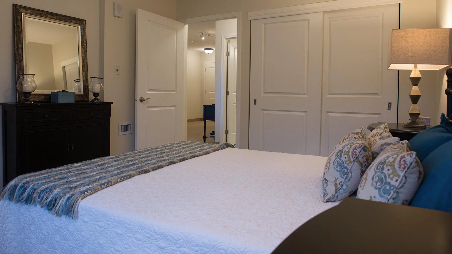 A bed and dresser in an Everitt Gardens suite