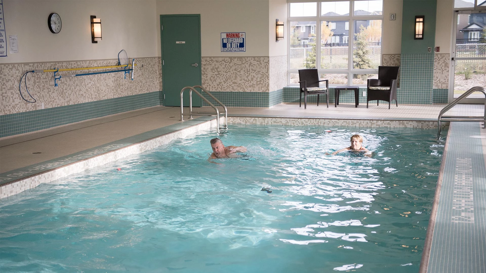 A senior couple swimming in an indoor pool at Everitt Gardens in St. Albert