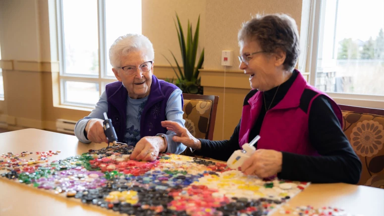 Two seniors enjoying crafts together